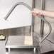 A hand using a Vollrath Redco Cheese Blocker to cut cheese on a machine.