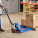 A man pushing a Lavex pallet jack with boxes on it.