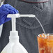 a hand in a glove holding a white bottle