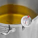 A metal pot filled with oil features an AvaTemp 12-inch candy and deep fry probe thermometer clipped to the side.