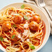 A plate of spaghetti with meatballs and sauce with a fork.