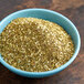 A bowl of McCormick Za'atar seasoning on a wood surface.