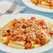 A plate of pasta with Lawry's spaghetti sauce and parmesan cheese with a fork.