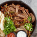 A pan of food with meat and vegetables seasoned with Lawry's Fajitas Seasoning Mix.