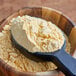 A spoonful of Zatarain's Seasoned Fish Fri powder in a wooden bowl.