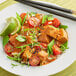 A plate of THAI Kitchen red curry with vegetables and rice with a lime wedge.