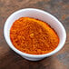 A bowl of McCormick Moroccan seasoning on a wooden table.