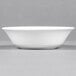 A white bowl on a grey surface.