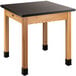 A National Public Seating science lab table with a black phenolic top and wood legs.