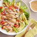 A bowl of salad with Zatarain's Creole Mustard sauce on a table.