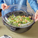 a clear plastic container with a lid on top of a salad