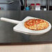 An American Metalcraft pizza peel with a pizza on it.