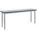 A long rectangular table with silver legs and a gray top.