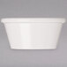 An ivory melamine oval ramekin on a gray surface.