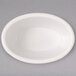 A white oval Carlisle ramekin on a gray surface.