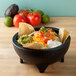 A bowl of food with tortilla chips and salsa in a Mexican restaurant.