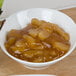 A bowl of Lucky Leaf spiced apple cobbler filling on a wood table.