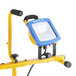 A blue and yellow Voltec LED work light on a stand.
