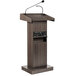 A wooden Oklahoma Sound ribbonwood lectern with a wireless microphone.