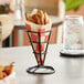 An American Metalcraft black metal square fry cone holder with fries inside.