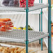 a shelf with plastic containers of vegetables and carrots