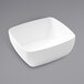 An American Metalcraft white rectangular melamine bowl on a gray surface.