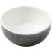 A white bowl with a black speckled design.