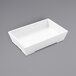 An American Metalcraft white rectangular melamine bowl on a gray surface.