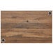 A wood table top with a knotty pine wood grained surface and holes for wireless chargers.