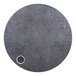 A circular grey surface with a round metal circle and a white dot.