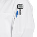 A person wearing a white Uncommon Chef long sleeve chef coat with a pen in the pocket.