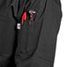 A black Uncommon Chef coat with a pocket and pen holder.