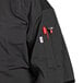 A black Uncommon Chef Delray short sleeve chef coat with a mesh back and a pocket.