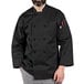 A man wearing a black Uncommon Chef 3/4 sleeve chef coat.