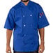 A man wearing a blue Uncommon Chef short sleeve chef coat with royal blue trim.