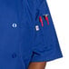 A man wearing a royal blue Uncommon Chef short sleeve chef coat.