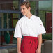 A man wearing an Uncommon Chef white short sleeve chef coat with a mesh back.