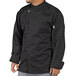 A man wearing a black Uncommon Chef long sleeve chef coat.