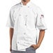 A man wearing a white Uncommon Chef Montego Pro Vent chef coat with mesh back.