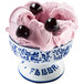 a bowl of pink ice cream with black cherries