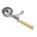 A stainless steel ice cream disher with an ivory-colored thumb press handle, holding 3.25 oz.