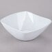 A white square bowl with a flared rim on a gray surface.