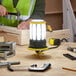 A man working with a Lind Equipment Beacon360 Blaze LED Portable Area Light on a table.