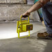 A man holding a Lind Equipment yellow rechargeable LED work light.