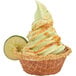 Soft serve lime ice cream in a waffle bowl with a lime wedge on top.