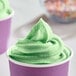 A cup of green DOLE Lime soft serve with sprinkles.