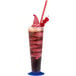 A glass of cherry soft serve with a straw and a cherry on top.