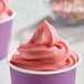 A cup of pink DOLE Soft Serve ice cream with sprinkles on top.