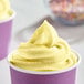 A close up of yellow soft serve in a cup.