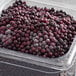 A plastic container of IQF frozen elderberries.